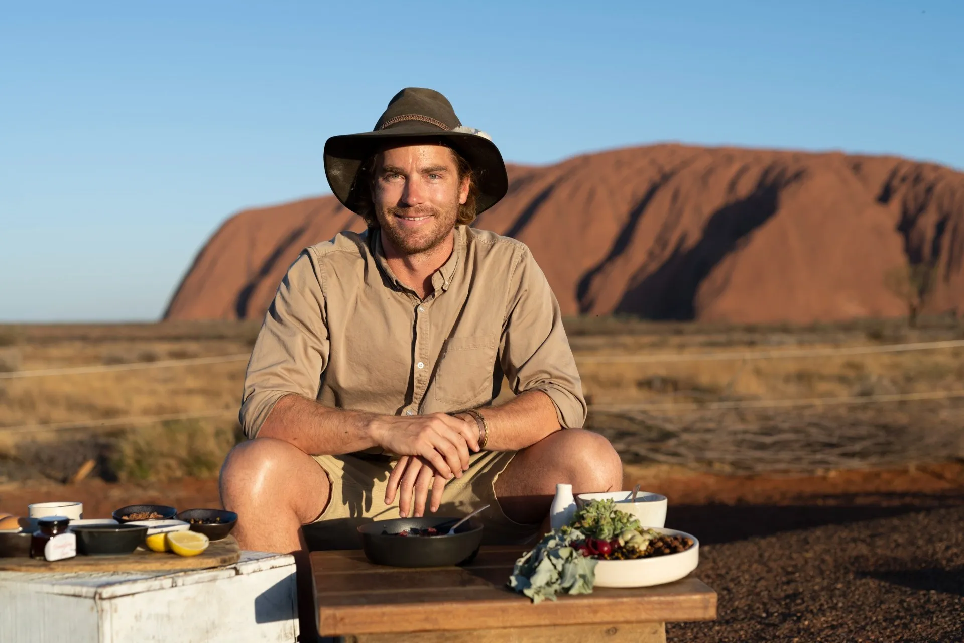Hayden Quinn cooking in front of Uluru