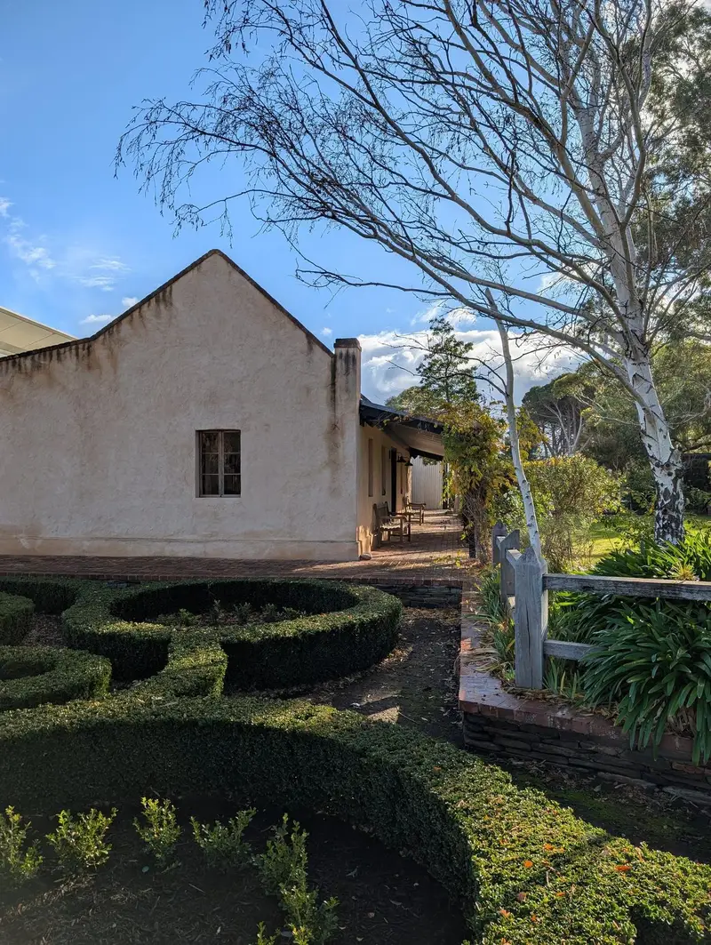 A stone cottage and clipped hedge garden in the Barossa