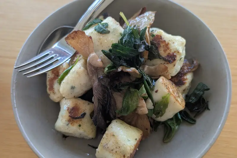 Bowl of gnocchi with mushrooms and greens