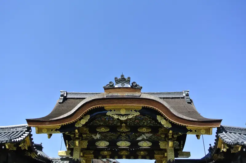 Ornate carved temple gate roof against a clear blue sky