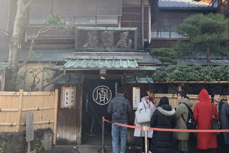 Traditional wooden townhouse with people queuing outside