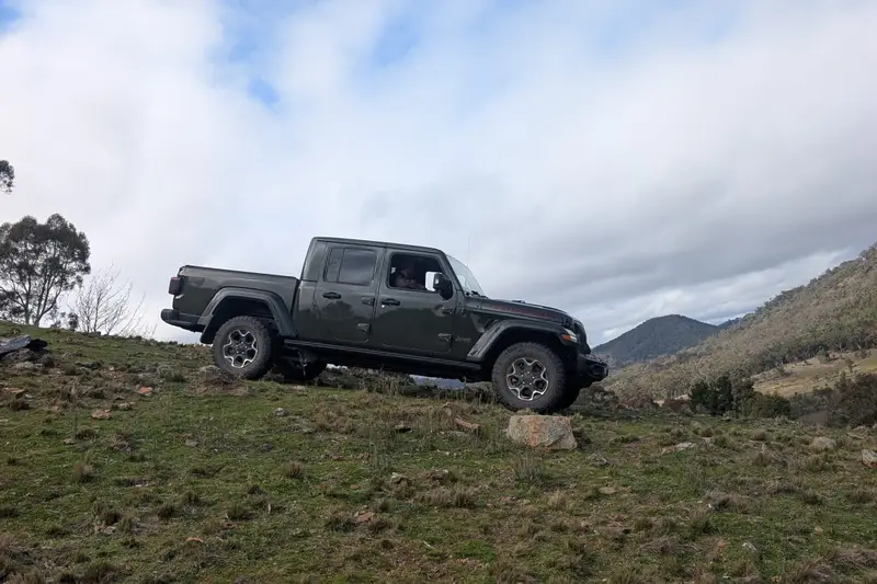 Ute parked on a grassy hilltop under clouds