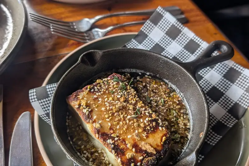 Crumbed dish in a small cast-iron pan on a checked napkin