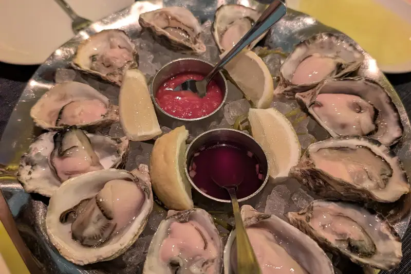 Platter of oysters with lemon and dipping sauces