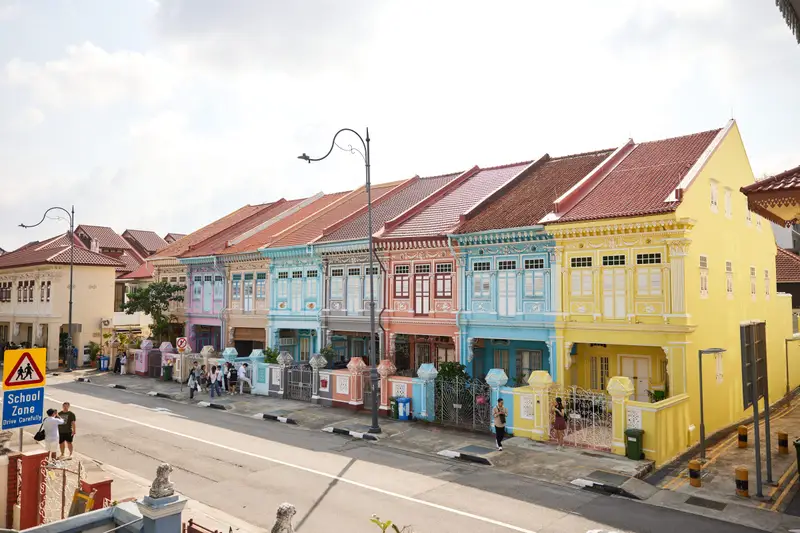 Row of colourful two-storey shophouses along a street