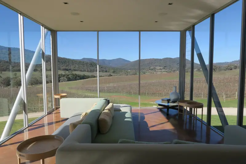 A glass lounge looking out over Mudgee vines