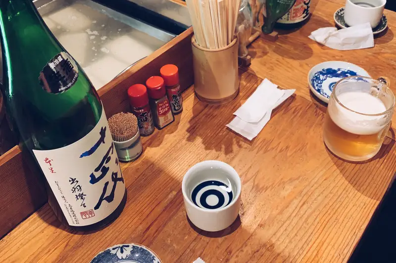 Sake and beer on the counter at Sakaba Ikura Mokuzai
